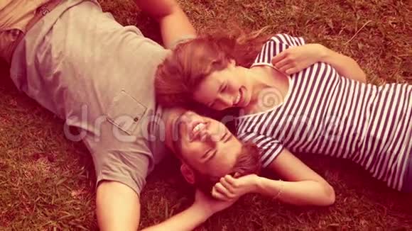 快乐可爱的情侣一起躺在公园里视频的预览图
