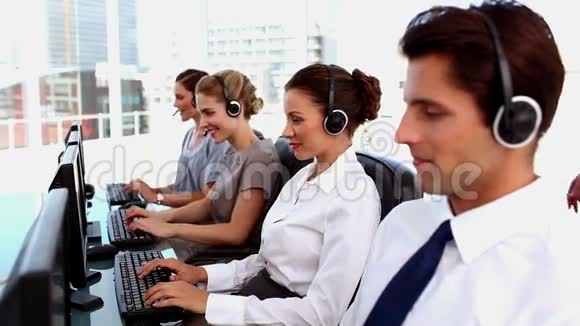 微笑的商务人士在呼叫中心工作视频的预览图