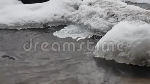 小溪在树林里冬天流水小河在雪地里自然景观视频的预览图