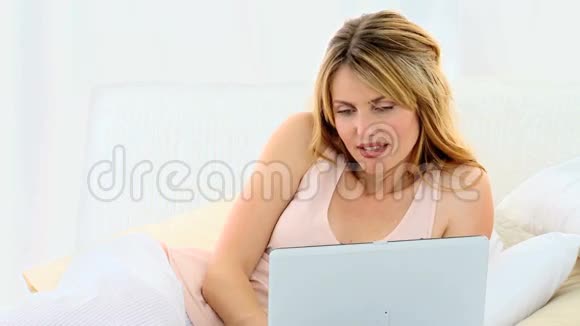 漂亮的休闲女人用笔记本电脑视频的预览图