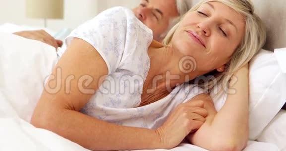 情侣在床上放松对着镜头微笑视频的预览图