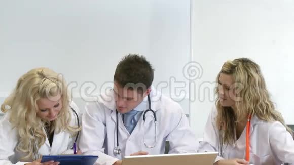 三位年轻医生一起工作视频的预览图