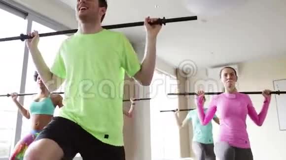 一群在健身房里用酒吧锻炼的人视频的预览图