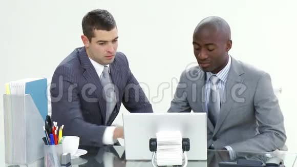 两个商人在办公室用笔记本电脑工作视频的预览图