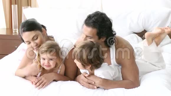 幸福的年轻家庭躺在床上视频的预览图