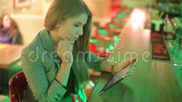 年轻女子在看数字平板电脑视频的预览图