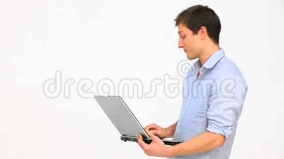 年轻人拿着笔记本电脑站起来视频的预览图