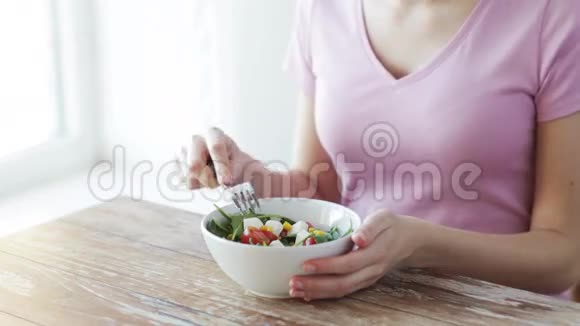 在家里吃沙拉的年轻女人视频的预览图