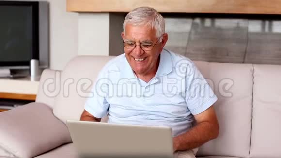在沙发上用笔记本电脑的老人视频的预览图