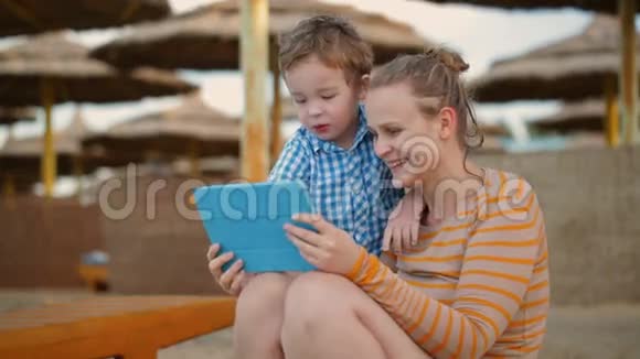 小男孩和妈妈在海滩度假胜地视频的预览图