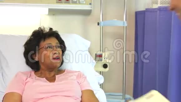医生与病床上的老年女病人交谈视频的预览图
