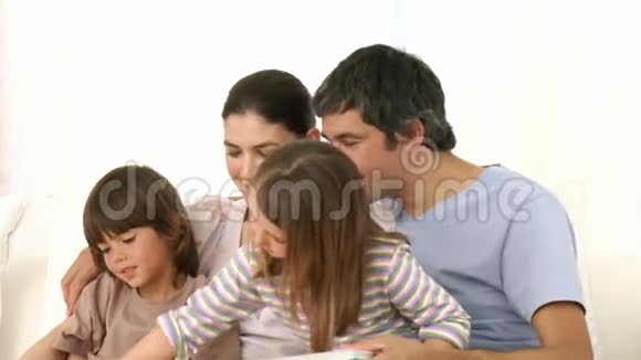 一家人坐在沙发上一起看书视频的预览图