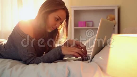 躺在床上用笔记本打字的黑发美女视频的预览图