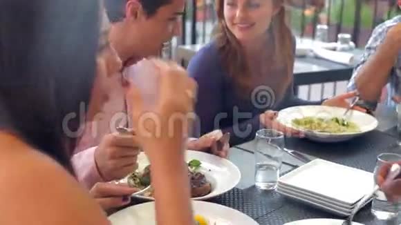 在户外餐厅享用美食的朋友们视频的预览图