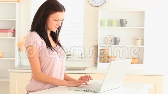 漂亮的黑发女人用笔记本电脑视频的预览图