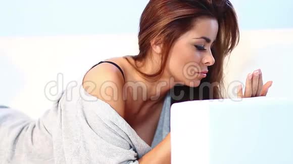 漂亮的年轻女人躺在沙发上视频的预览图