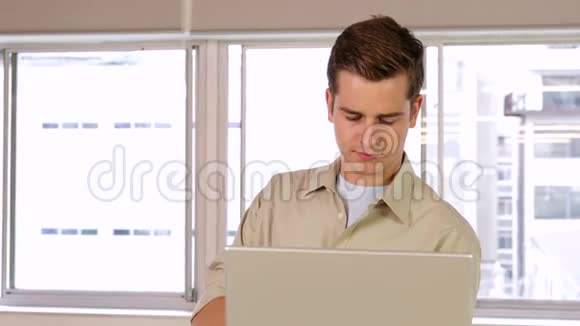 专注的商人在他的笔记本电脑上工作视频的预览图
