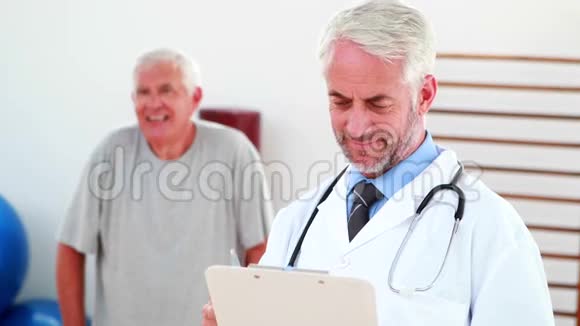 微笑的医生从剪贴板上阅读视频的预览图