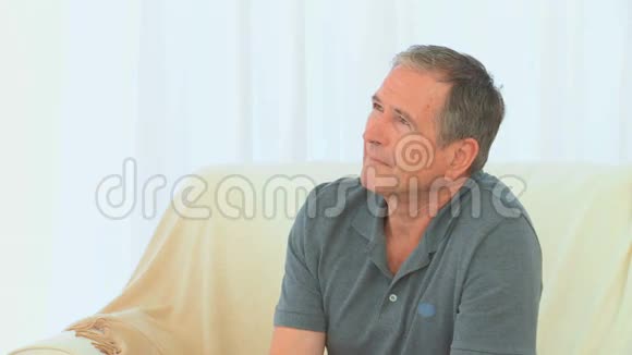 退休男子坐着看着摄像机视频的预览图