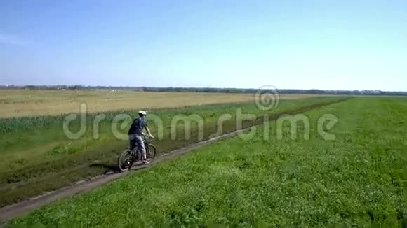 人在农村公路上骑自行车空中景观视频的预览图