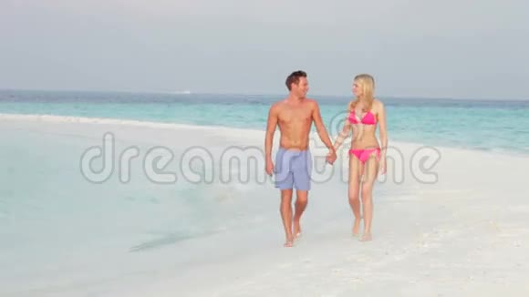 浪漫情侣漫步美丽热带海滩视频的预览图