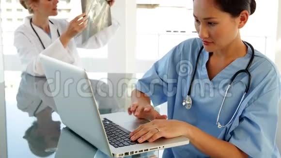 坐在桌旁的医生用笔记本电脑视频的预览图
