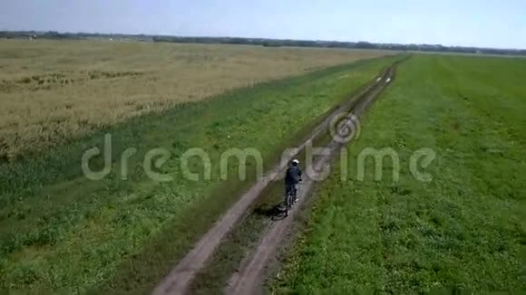 人在农村公路上骑自行车空中景观视频的预览图