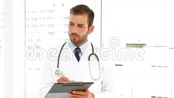 严重的医生在剪贴板上写字视频的预览图
