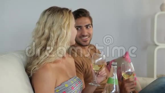 微笑的夫妇坐在沙发上喝酒视频的预览图