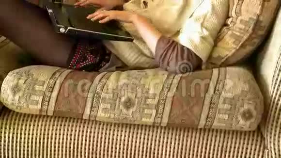 有魅力的女人坐在沙发上用笔记本电脑视频的预览图