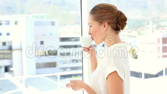 女商人喝着一杯咖啡对着镜头微笑视频的预览图