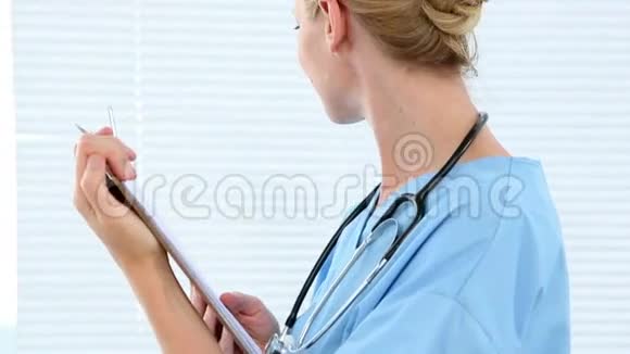 护士拿着剪贴板对着镜头微笑视频的预览图