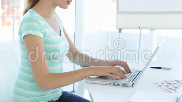 随便的女商人在她的笔记本电脑上打字视频的预览图