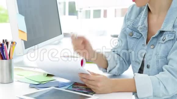 美丽的微笑创意设计师坐在办公桌前视频的预览图