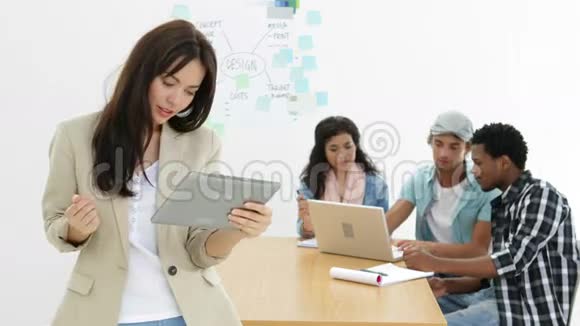 年轻的创意团队与使用平板电脑的女性合作视频的预览图
