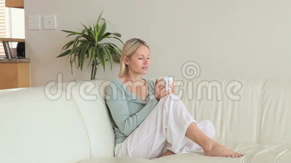 坐在沙发上喝咖啡的女人视频的预览图