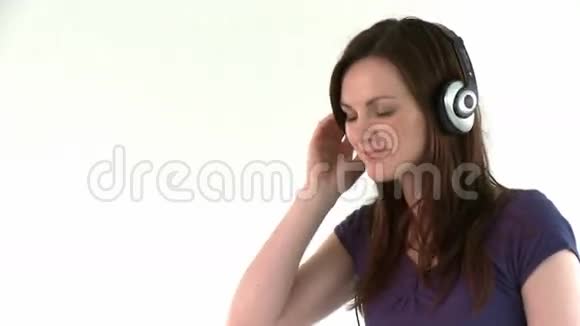 快乐的高加索女人带着耳机听音乐视频的预览图