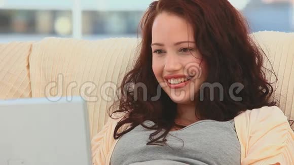 美丽的女人用她的笔记本电脑微笑视频的预览图