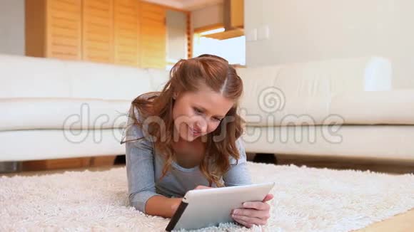 女人用平板电脑躺在地上视频的预览图