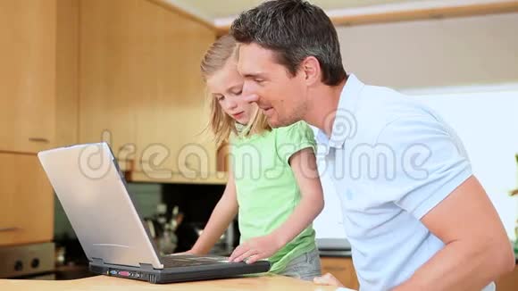 女儿在爸爸看的时候用笔记本电脑视频的预览图