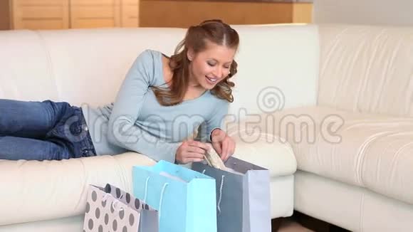 一个年轻的女人看着她的购物袋视频的预览图