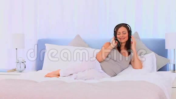 放松的女人听音乐视频的预览图