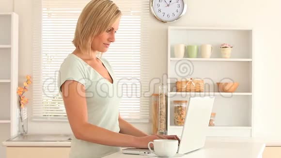 年轻女子用手提电脑喝咖啡视频的预览图