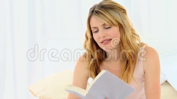 漂亮的金发女人在看书视频的预览图