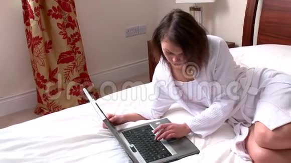 坐在床上用笔记本电脑的冷静的女人视频的预览图