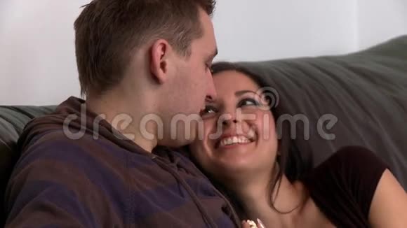 一对浪漫情侣坐在沙发上的肖像视频的预览图