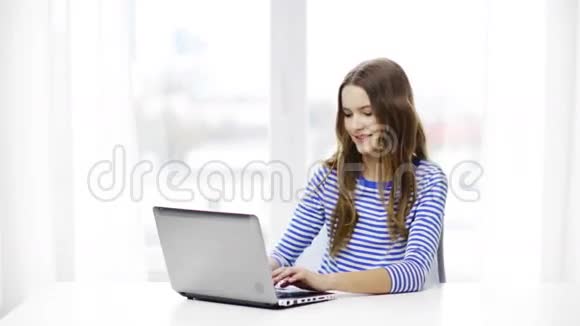 带着笔记本电脑在家微笑的少女视频的预览图