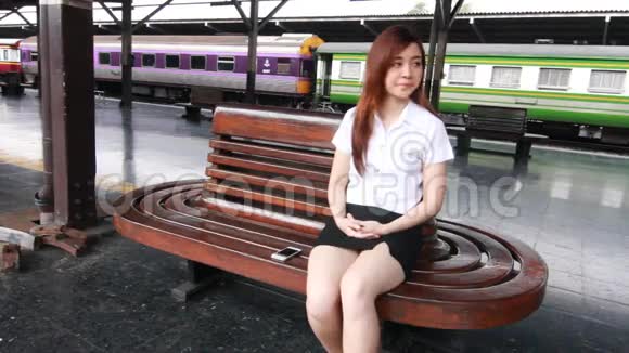 泰国成人学生大学漂亮女孩打智能手机的画像视频的预览图