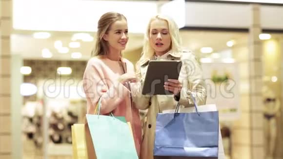 带平板电脑和购物袋的快乐年轻女性视频的预览图