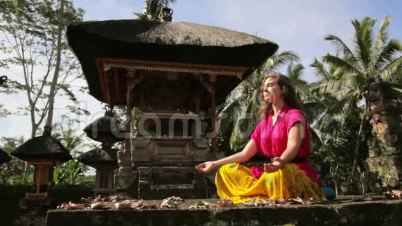 白种人妇女在巴厘岛寺庙冥想瑜伽视频的预览图